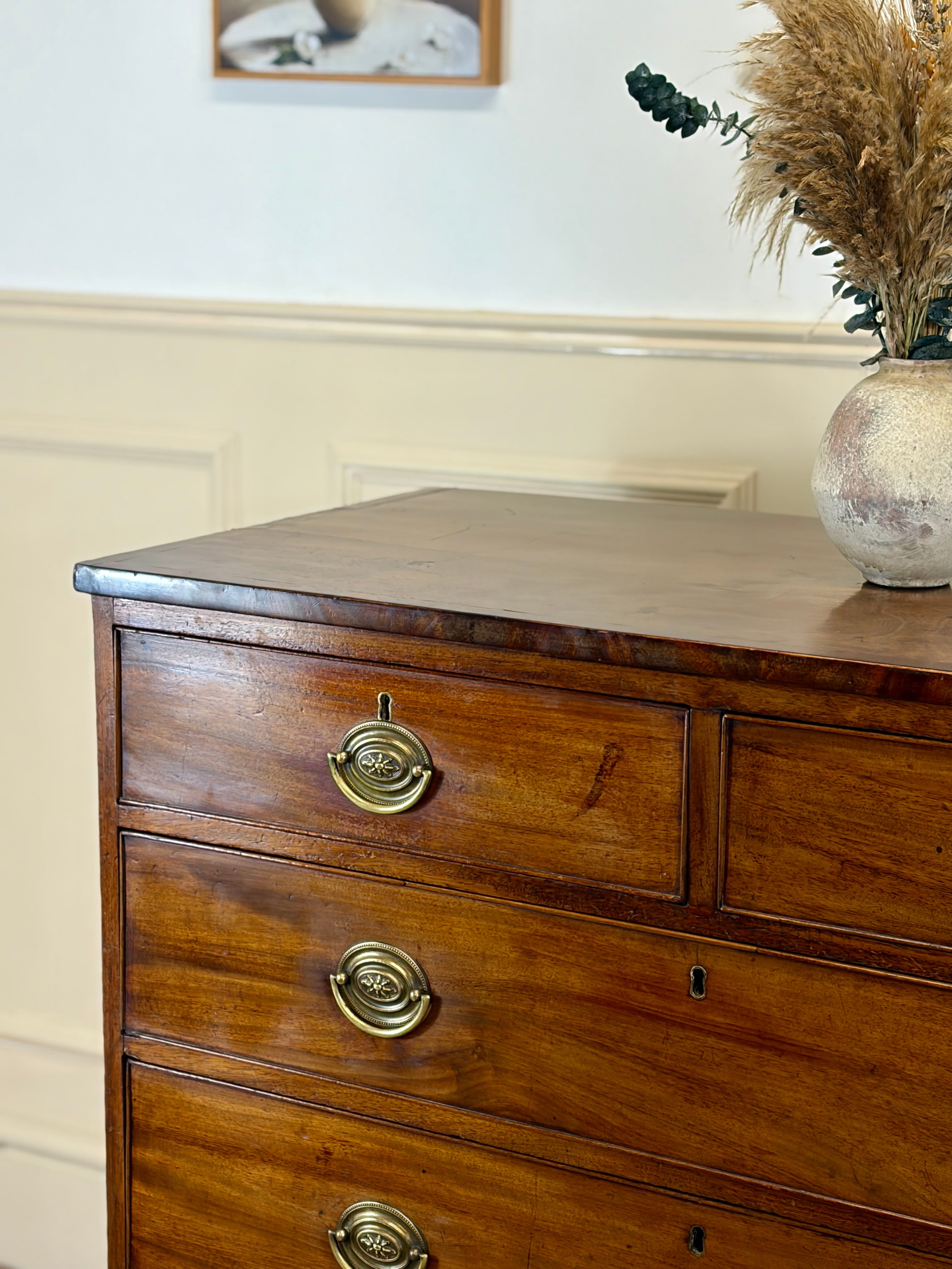 Wooden dresser with brass handles in a room setting