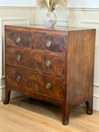 Wooden dresser with three drawers and decorative handles in a room setting.