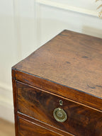 Wooden drawer with a decorative metal plaque on a neutral background