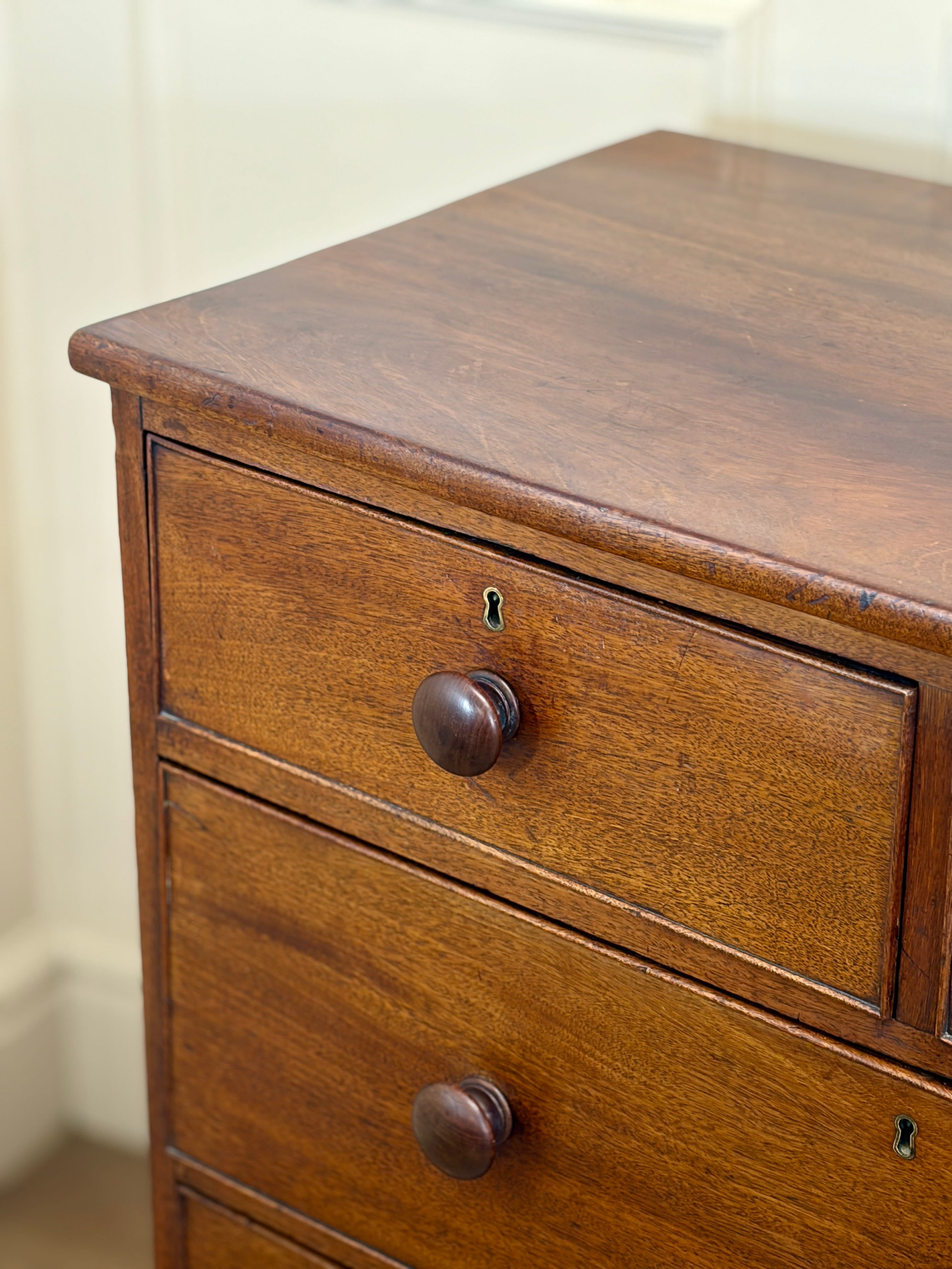 Wooden dresser with two drawers and metal knobs on a plain background