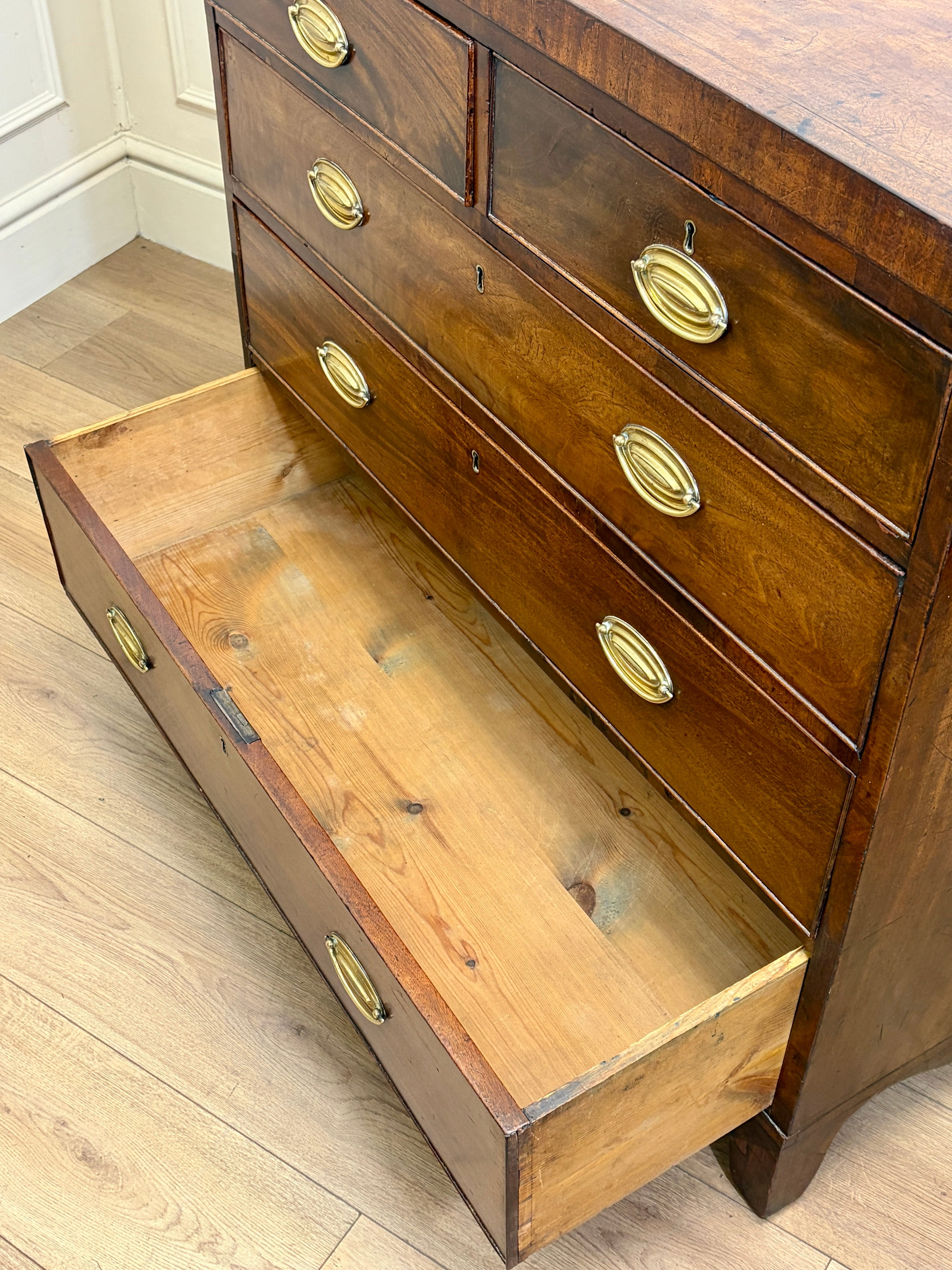 Wooden dresser with open drawer on a wooden floor