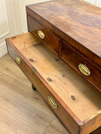 Wooden desk with brass handles on a wooden floor