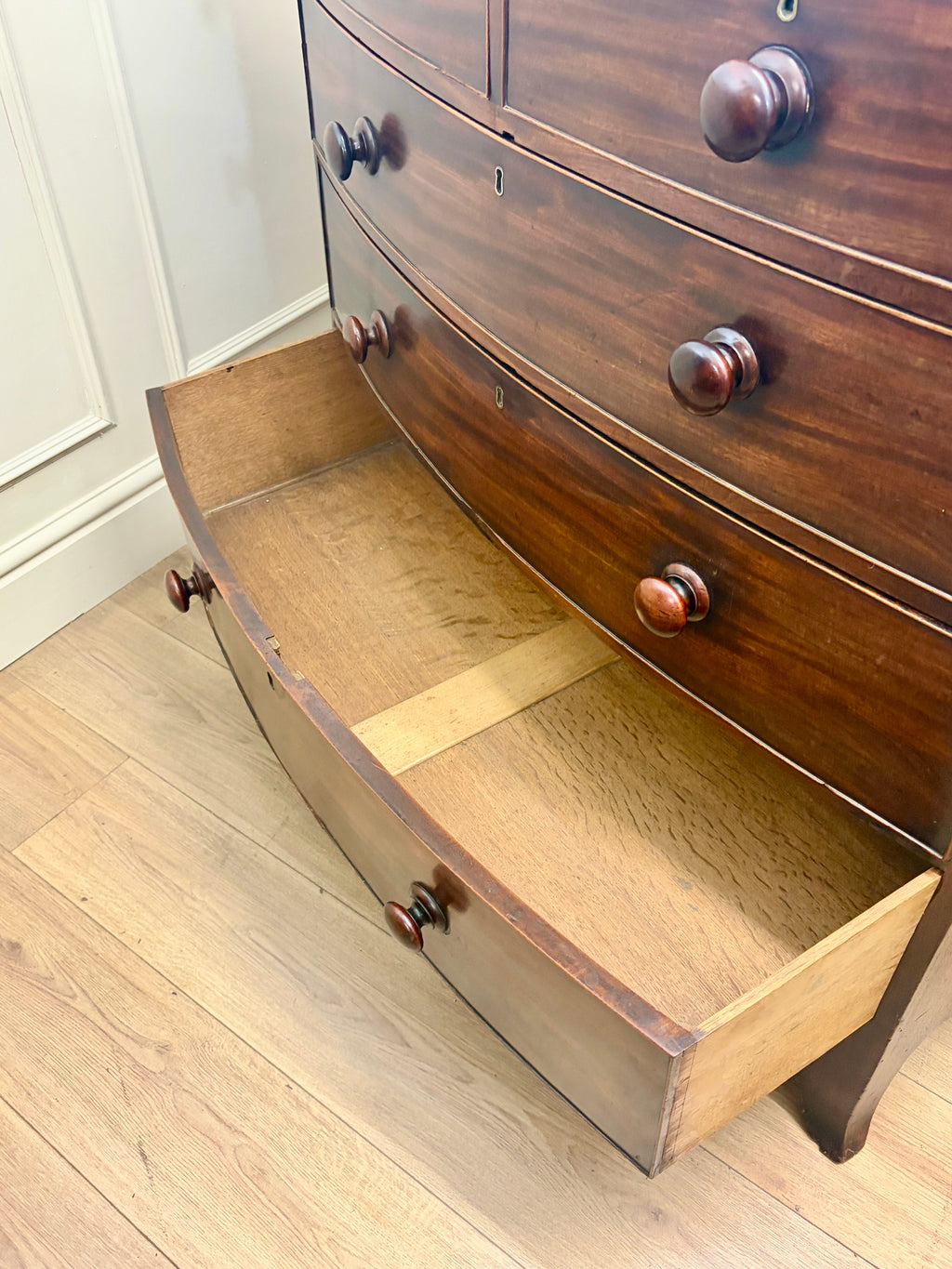 Wooden dresser with an open drawer on a wooden floor