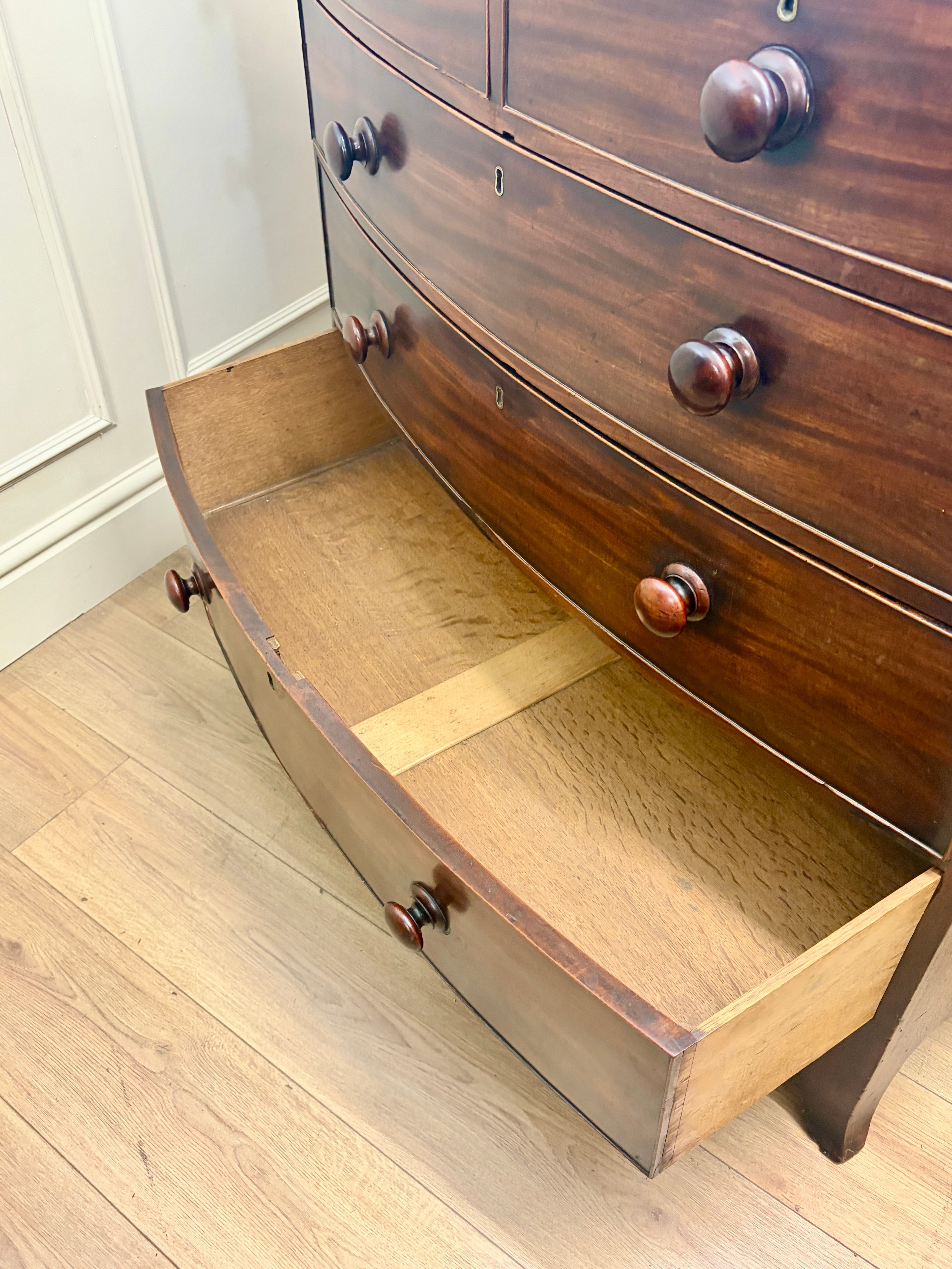Wooden dresser with an open drawer on a wooden floor