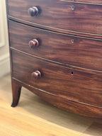 Wooden dresser with three drawers on a wooden floor.
