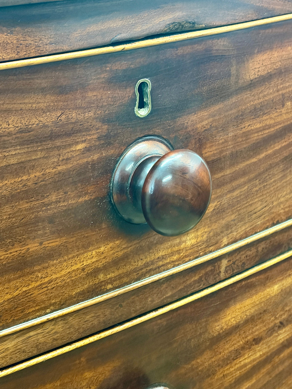 Wooden drawer with a brass handle and keyhole