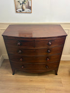 Wooden dresser with curved design on a wooden floor.