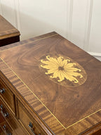 Wooden furniture with a decorative gold emblem on a white paneled wall.