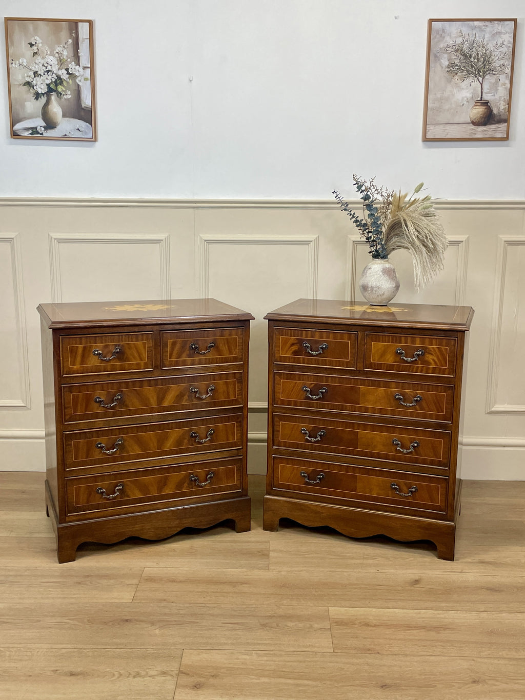 Two wooden dressers with drawers against a wall with decorative elements.