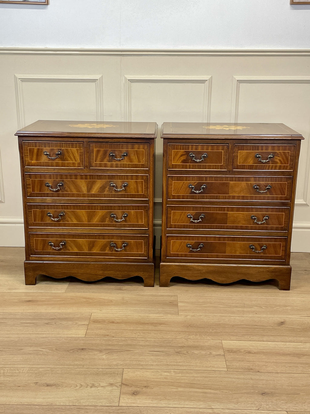 Pair of wooden dressers with a checkered pattern on a wooden floor.