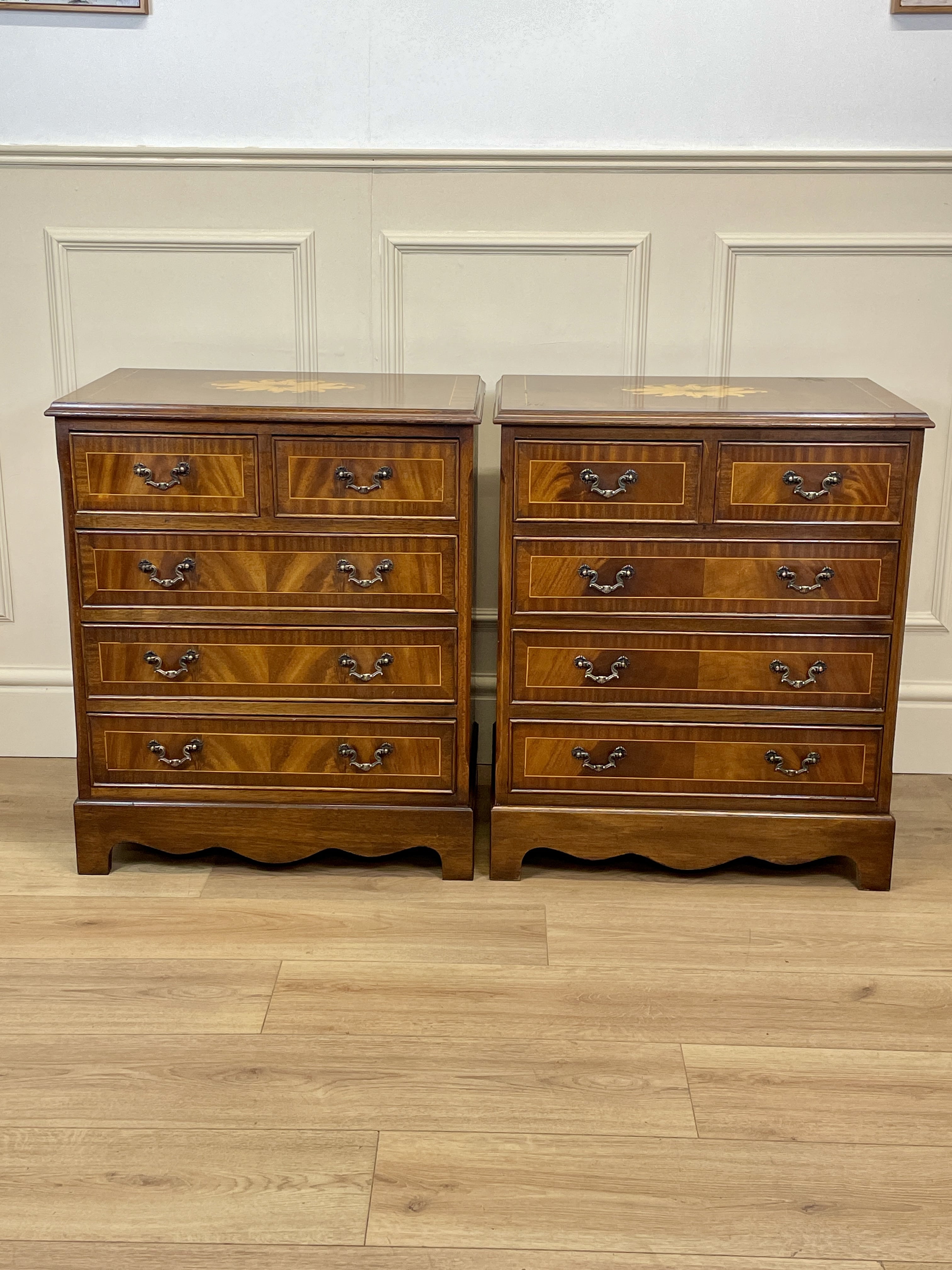 Pair of wooden dressers with a checkered pattern on a wooden floor.