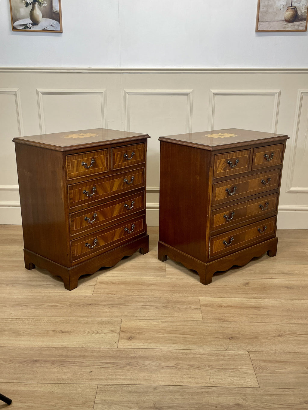 Two wooden nightstands with multiple drawers on a wooden floor.
